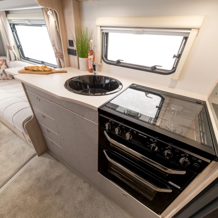 Another top angle view of the kitchen area inside the Elddis Whirlwind 520. This time round, you can see the cooker and grill alongside the sink towards the left leading toward the sofa area.