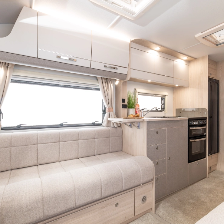 another interior side view of the Whirlwind 520. It shows part of the sofa, kitchen area, and door leading to the rear bathroom.