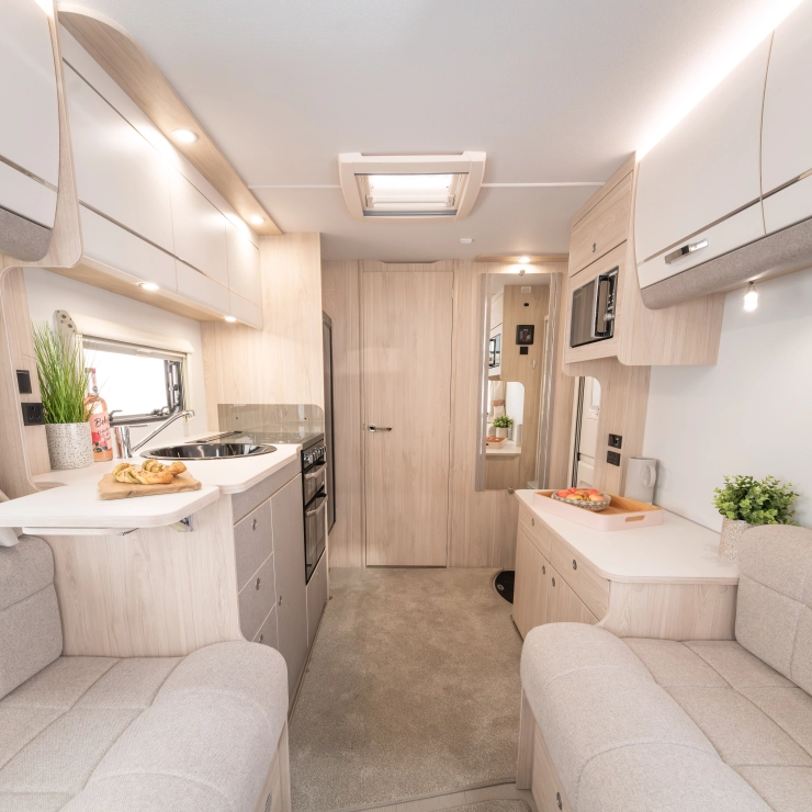 Interior front view of the Whirlwind 520. It shows part of the sofa, kitchen area, and door leading to the rear bathroom.