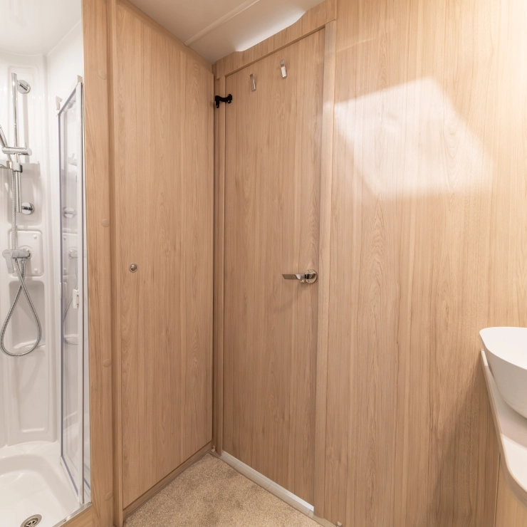 Another angle of the rear bathroom inside the Elddis Whirlwind 520 caravan. It shows the shower area, door and sink.